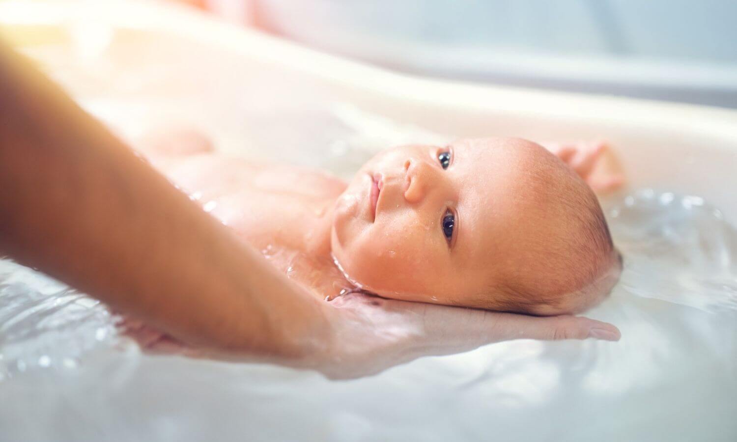noworodek w trakcie kąpieli w wanience