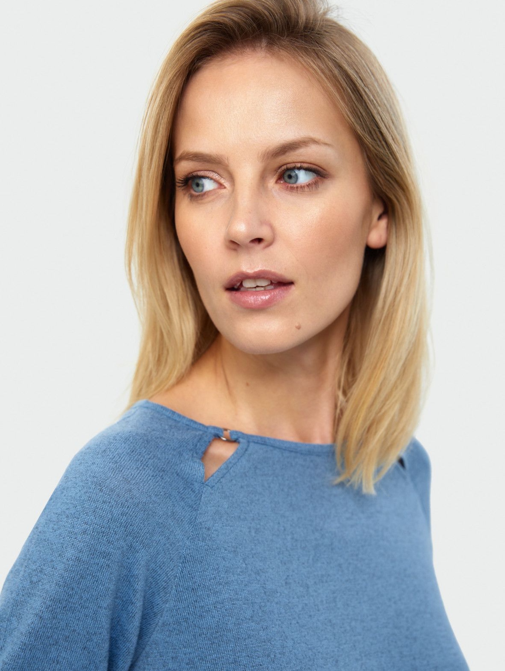 Dopasowany niebieski sweter damski z ozdobnymi wycięciami
