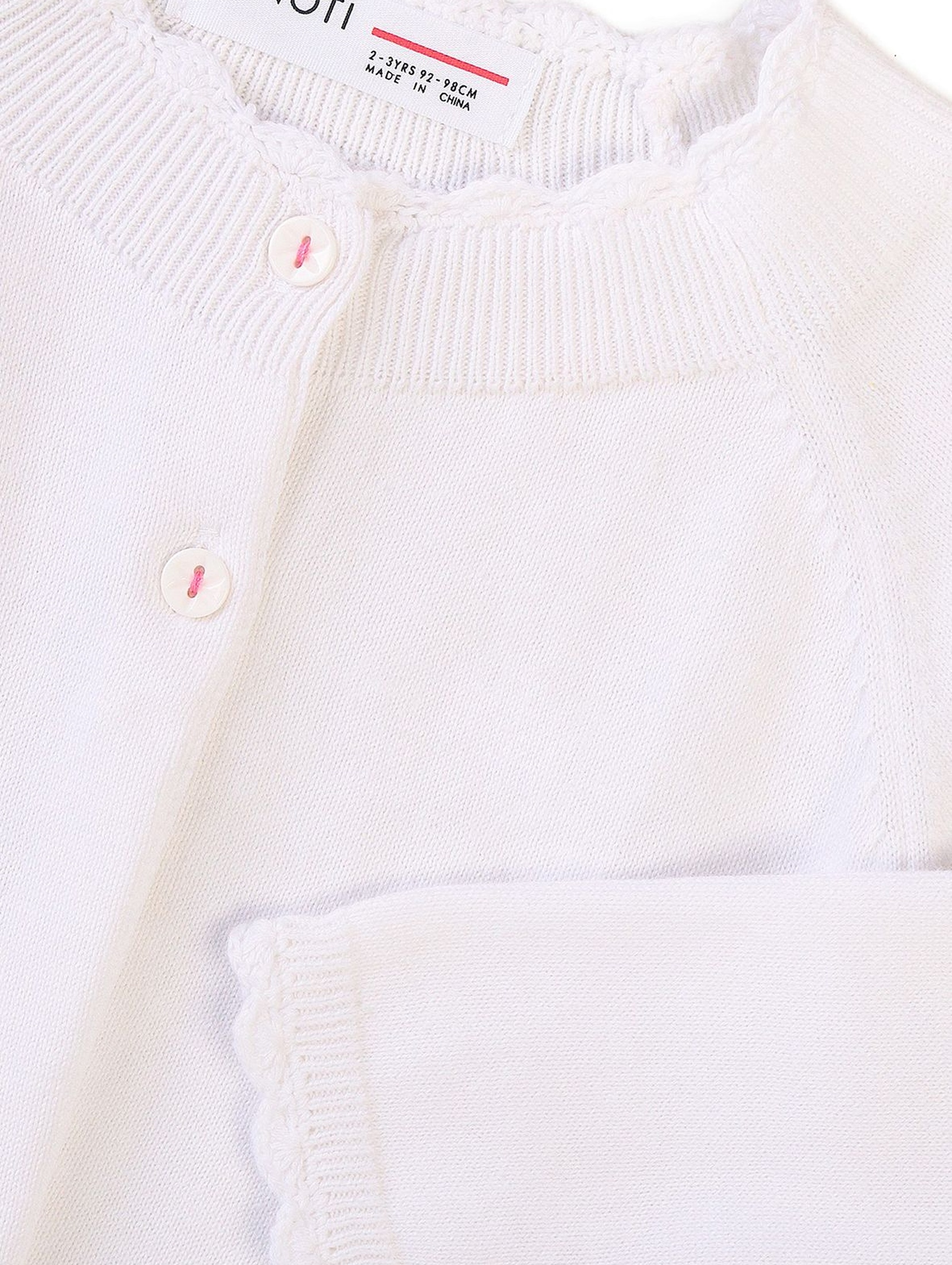 Biały niemowlęcy sweter z falbanką na dole