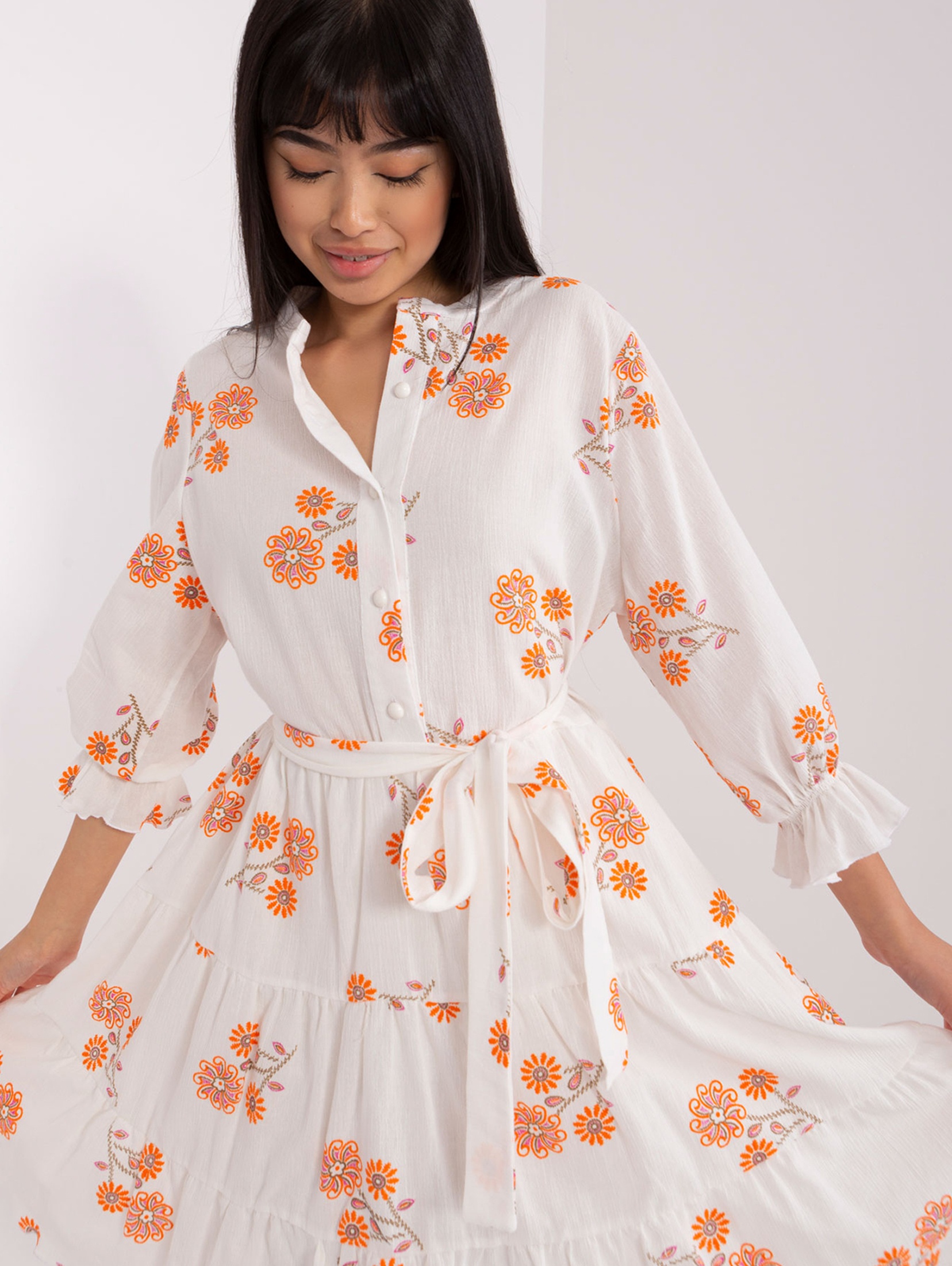 Biało-pomarańczowa wzorzysta sukienka z falbaną