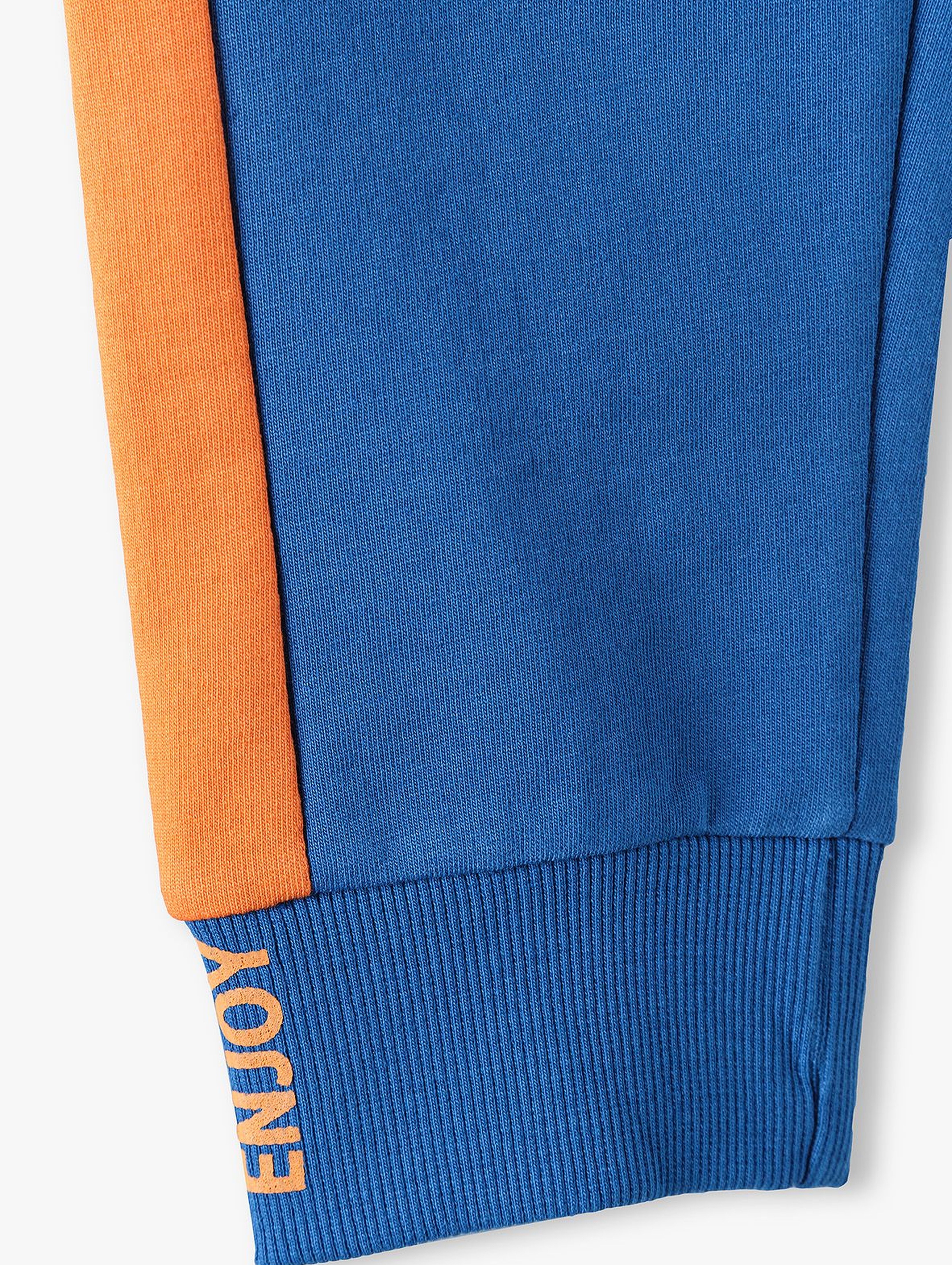 Bawełniane spodnie dresowe chłopięce niebieskie z pomarańczowymi wstawkami
