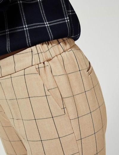 Spodnie cygaretki z gumką w pasie - beżowe w kratę