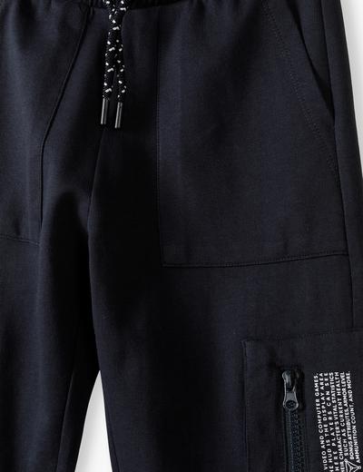 Czarne spodnie dresowe chłopięce z dekoracyjną kieszonką