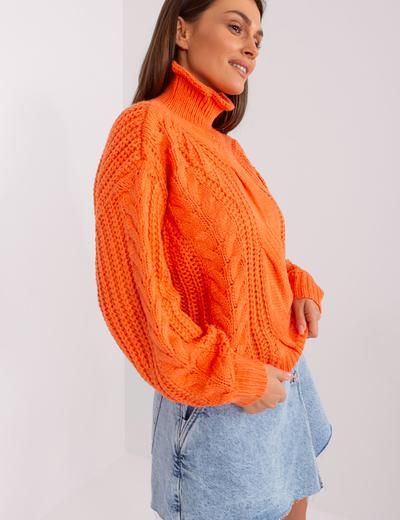 Pomarańczowy sweter oversize z warkoczami