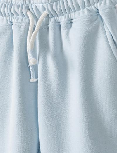 Błękitne spodnie dresowe niemowlęce z białymi paskami